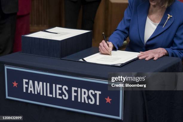 House Speaker Nancy Pelosi, a Democrat from California signs the H.R. 748, Coronavirus Aid, Relief, and Economic Security Act, during a ceremony at...