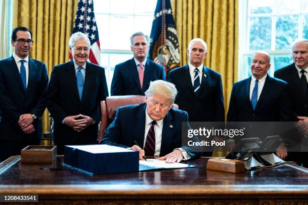 President Donald Trump signs H.R. 748, the CARES Act in the Oval Office of the White House on March 27, 2020 in Washington, DC. Earlier on Friday,...