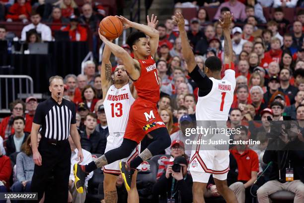 Anthony Cowan Jr. #1 of the Maryland Terrapins passes the ball in while being guarded by CJ Walker and Luther Muhammad of the Ohio State Buckeyes at...