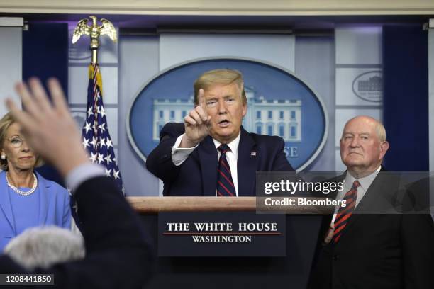 President Donald Trump, center, speaks as Betsy DeVos, U.S. Secretary of education, left, and Sonny Perdue, U.S. Secretary of agriculture, listen...