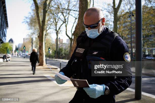 Policeman controls the laissez-passer and the passport of a passer-by in Toulouse, France, on March 27, 2020. The lockdown due to the Covid-19...