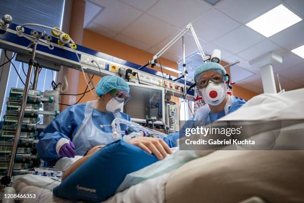 Medical workers wearing protective gear treat a patient infected with the COVID-19 novel coronavirus at the intensive care unit of the General...