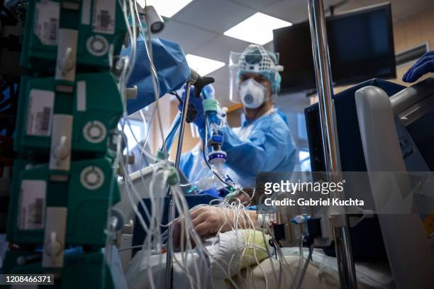 Medical workers wearing protective gear treat a patient infected with the COVID-19 novel coronavirus at the intensive care unit of the General...