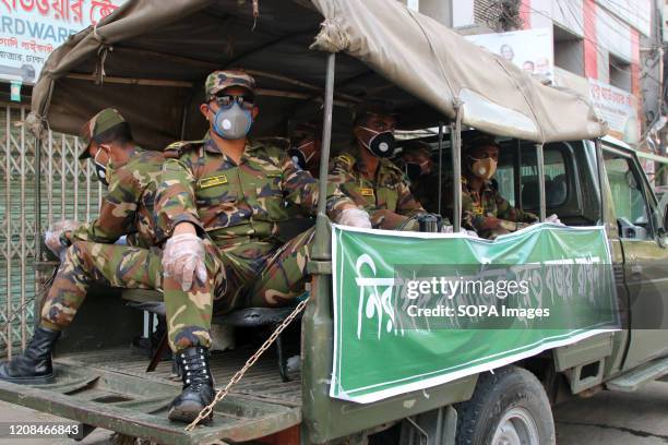 Army soldiers wearing protective masks and gloves on a truck patrol through streets during government-imposed lockdown amid concerns of corona virus...