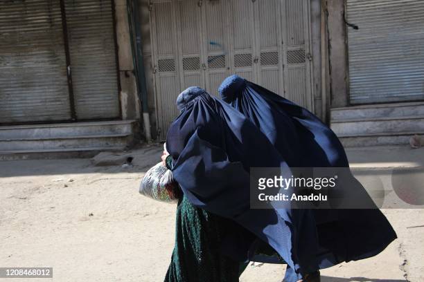 Afghan burqa clad women walk past deserted markets, in Kabul, Afghanistan, 28 March 2020. Kabul, a city with an estimated population of six million,...