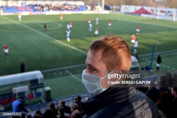 Supporter of FC Minsk, wears a facemask for protective measures amid concerns over the spread of the COVID-19, as he attends the Belarus Championship...
