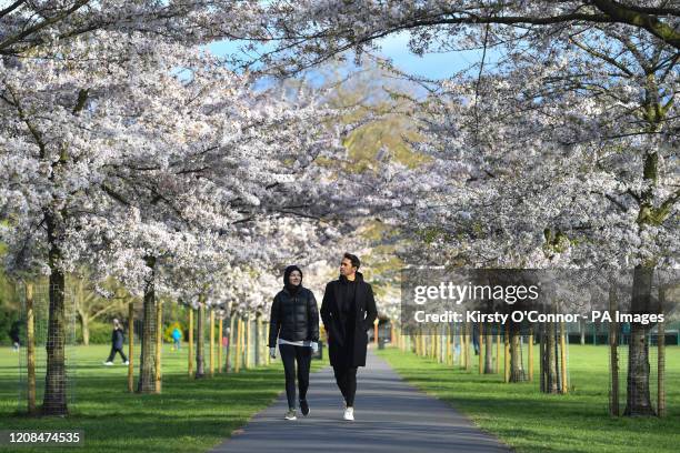 People walk through Battersea Park in London, as the UK continues in lockdown to help curb the spread of the coronavirus.