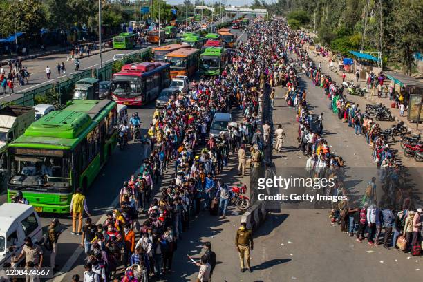 Crowds of Indian migrant workers wait to board buses to return to their native villages as a nationwide lockdown continues in an attempt to stop the...