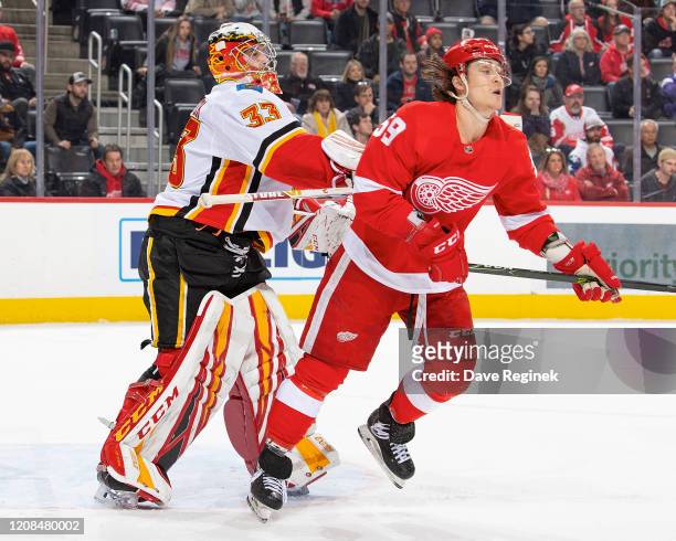 David Rittich of the Calgary Flames pushes Tyler Bertuzzi of the Detroit Red Wings during an NHL game at Little Caesars Arena on February 23, 2020 in...