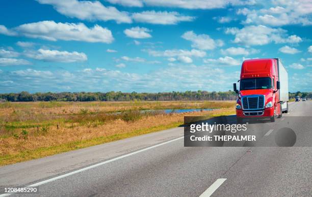 red semi-truck on the highway - transportation truck stock pictures, royalty-free photos & images