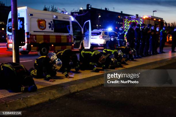 Firemen kneel before sanitation workers to show their gratitud for their work tackling Covid-19, in Madrid, Spain, on March 28, 2020.