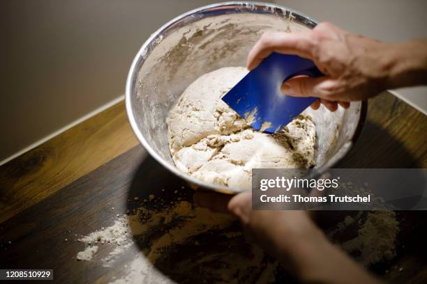 Symbol photo on the subject of bread baking. Bread dough is taken out of a bowl with a dough scraper on March 25, 2020 in Berlin, Germany.