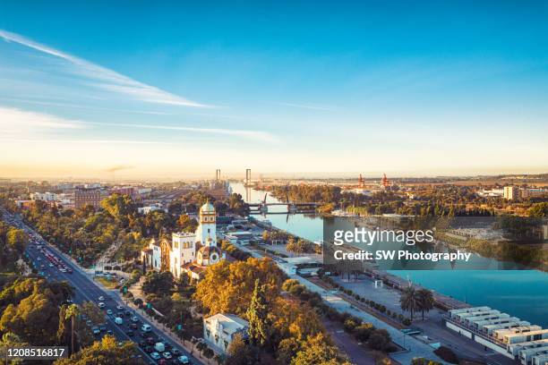 drone photo of the guadalquivir river in seville, spain - seville stock pictures, royalty-free photos & images