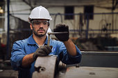Engineers and skilled technicians are maintaining machinery. Technicians and engineers are working and repairing machines in industrial plants.