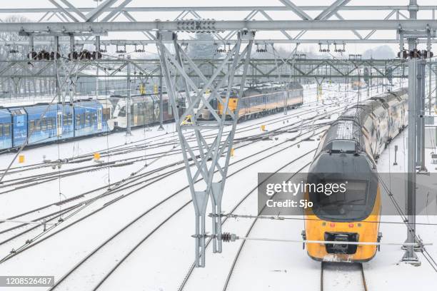 ns intercity train driving through the snow in winter - train yard at night stock pictures, royalty-free photos & images