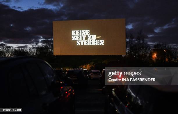 The screen of a drive-in cinema shows an advertising for the new James Bond movie 'No Time to Die' in Essen, western Germany, on March 29 as normal...