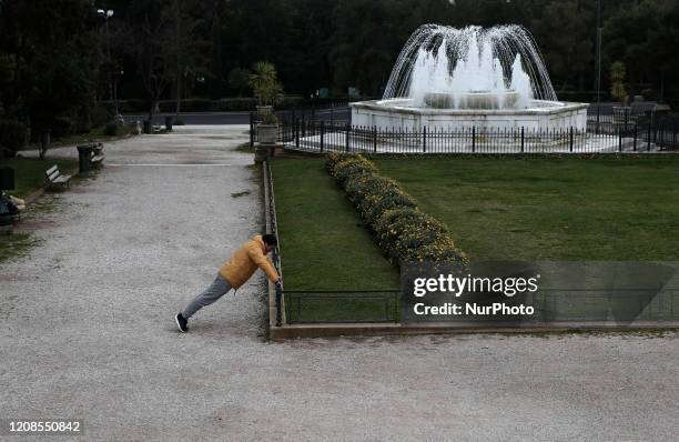 Man stretches at the national garden area during a nationwide lockdown to contain the spread of the coronavirus disease, in central Athens, Greece on...