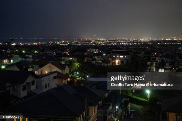 illuminated residential district by the sea in kanagawa prefecture of japan - kanagawa stockfoto's en -beelden