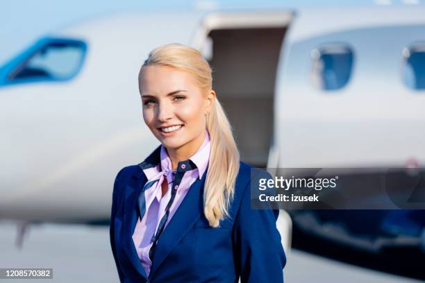 beautiful air stewardess in front of private airplane - air stewardess stock pictures, royalty-free photos & images