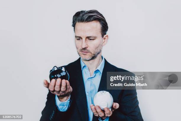 businessman with black and white piggy bank. - yin och yang bildbanksfoton och bilder