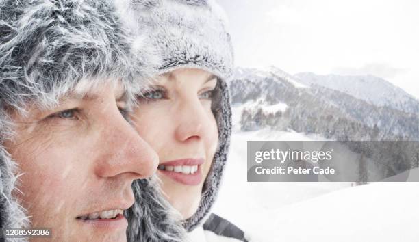 couple looking out at snowy scene - gesicht kälte stock-fotos und bilder