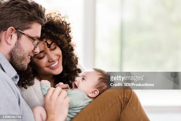 adorable young family with newborn - multiracial person stock pictures, royalty-free photos & images