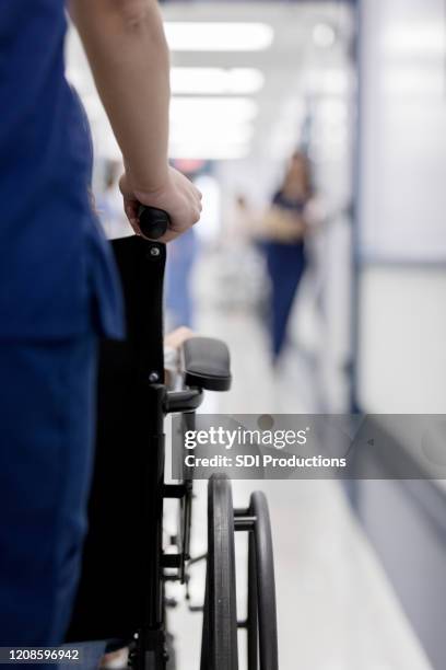 hospital orderly pushes patient in wheelchair - nurse leaving stock pictures, royalty-free photos & images