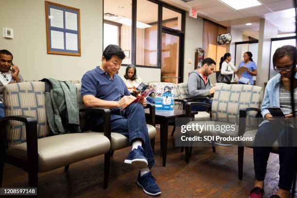 de wachtende ruimte van de bezige dagchirurgie - patients in doctors waiting room stockfoto's en -beelden