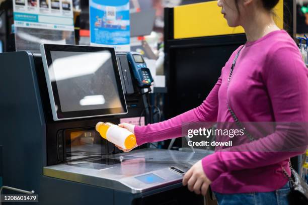 female checkout by automatic payment machine in supermarket - automatic stock pictures, royalty-free photos & images