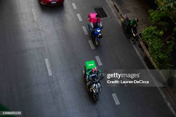 Motorbike food delivery drivers on Sukhumvit Road on March 30, 2020 in Bangkok, Thailand. Due to the spread of Covid-19, Bangkok called for an...