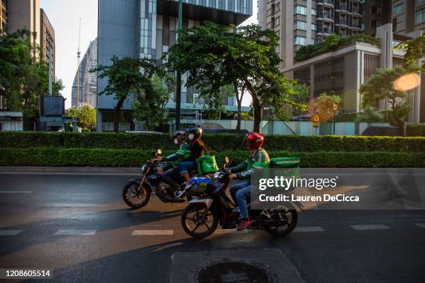 Motorbike food delivery drivers on Sukhumvit Road on March 30, 2020 in Bangkok, Thailand. Due to the spread of Covid-19, Bangkok called for an...