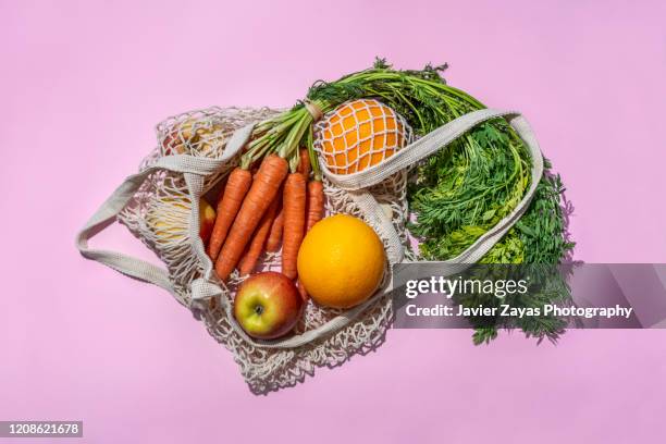 reusable cotton mesh bag with fruit and vegetables - comida vegetariana fotografías e imágenes de stock