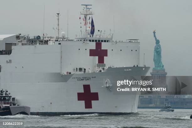 The USNS Comfort medical ship moves up the Hudson River past the Statue of Liberty as it arrives on March 30, 2020 in New York. A military hospital...