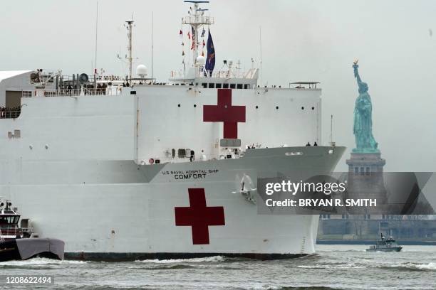The USNS Comfort medical ship moves up the Hudson River past the Statue of Liberty as it arrives on March 30, 2020 in New York. A military hospital...