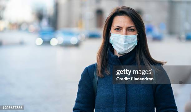 vrouw met gezichts beschermend masker - masker stockfoto's en -beelden