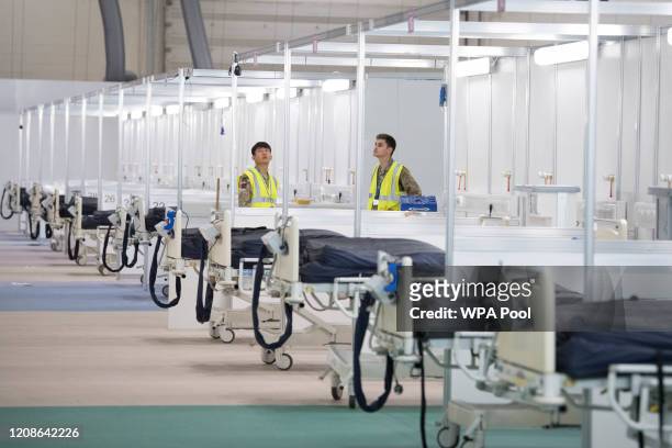 Soldiers and private contractors help to prepare the ExCel centre which is being made into the temporary NHS Nightingale hospital, comprising of two...