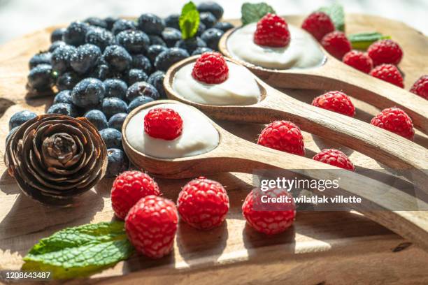 yogurt with spoons,healthy breakfast with fresh greek yogurt, muesli and berries on background - joghurtbecher stock-fotos und bilder