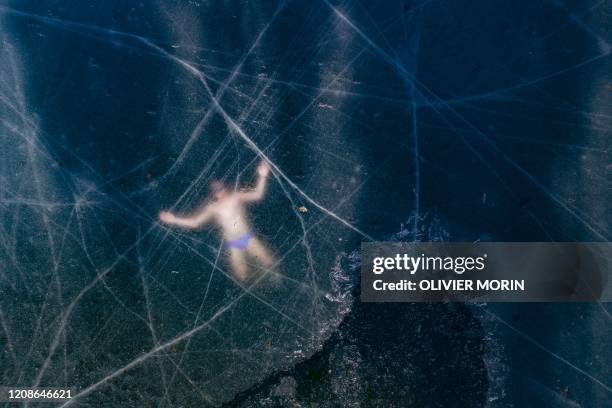 Aerial view shows Finland's freediver Kristian Maki-Jussila swimming under the ice of a frozen lake on March 28, 2020 near Vaasa, Finland. - On March...