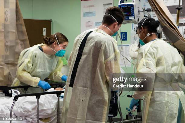 In this handout released by the U.S. Navy, Sailors assigned to the hospital ship USNS Mercy treat the first patient from Los Angeles medical...