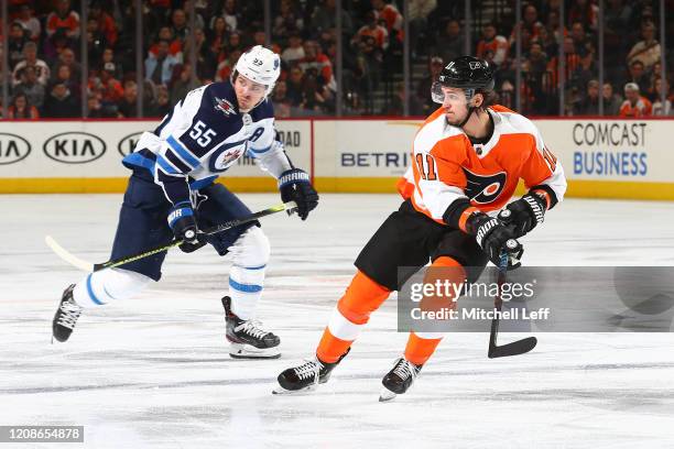 Travis Konecny of the Philadelphia Flyers skates against Mark Scheifele of the Winnipeg Jets at the Wells Fargo Center on February 22, 2020 in...