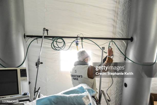 Person sets up power and oxygen lines in an emergency field hospital to aid in the COVID-19 pandemic in Central Park on March 30, 2020 in New York...