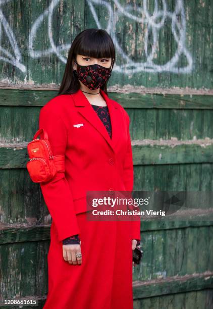 Kozue Akimoto is seen wearing face mask, red coat outside Marine Serre during Paris Fashion Week - Womenswear Fall/Winter 2020/2021 : Day Two on...