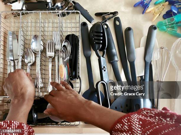 close-up of woman arranging spoons in cutlery drawer - arrangement stock pictures, royalty-free photos & images