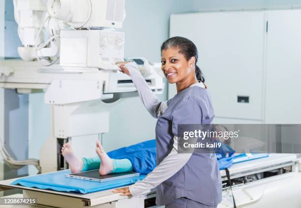 technologist taking x-ray of girl's foot - doctor looking over shoulder stock pictures, royalty-free photos & images