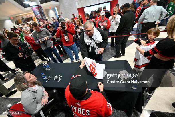 Dave Ayres signs autographs for fans during the game between the Dallas Stars and Carolina Hurricanes at at PNC Arena on February 25, 2020 in...