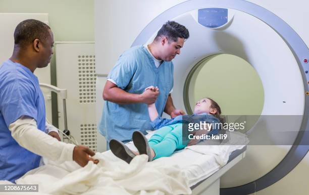 technologist talking to girl getting ct scan - radiographer stock pictures, royalty-free photos & images