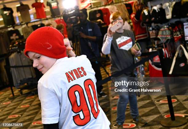 Fans buy t-shirts with the name and number of Dave Ayres during the game between the Dallas Stars and Carolina Hurricanes at at PNC Arena on February...