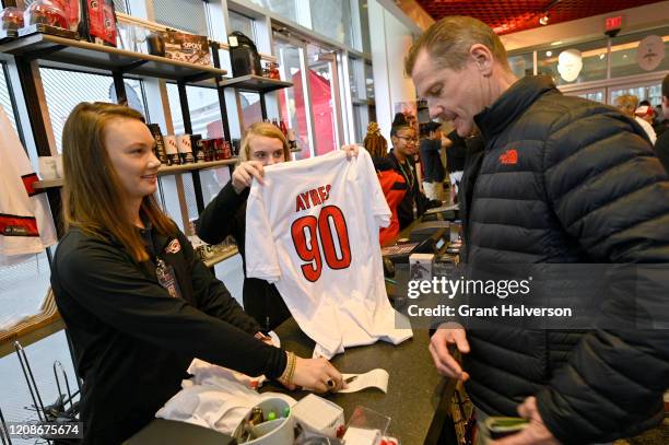 Fans buy T-shirts with the name and number of Dave Ayres during the game between the Dallas Stars and Carolina Hurricanes at at PNC Arena on February...