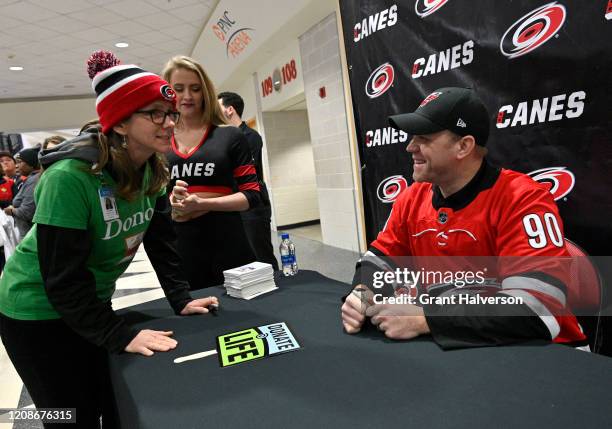 Dave Ayres signs autographs for fans during the game between the Dallas Stars and Carolina Hurricanes at at PNC Arena on February 25, 2020 in...
