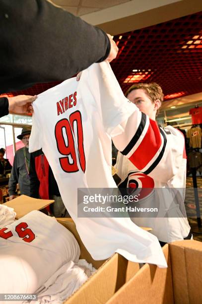 Fans buy T-shirts with the name and number of Dave Ayres during the game between the Dallas Stars and Carolina Hurricanes at at PNC Arena on February...